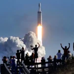 The crowd cheers at Playalinda Beach in the Canaveral National Seashore, just north of the Kennedy Space Center, during the launch of the SpaceX Falcon Heavy rocket, on Feb. 6, 2018.