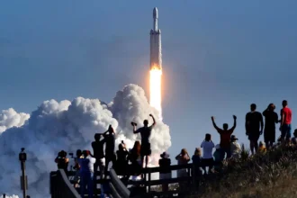 The crowd cheers at Playalinda Beach in the Canaveral National Seashore, just north of the Kennedy Space Center, during the launch of the SpaceX Falcon Heavy rocket, on Feb. 6, 2018.