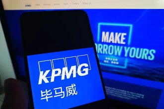 SUQIAN, CHINA - MAY 19, 2026 - A netizen is checking KPMG logo on his mobile phone and KPMG webpage on his computer in Suqian City, Jiangsu Province, China on May 19, 2026. (Photo credit should read CFOTO/Future Publishing via Getty Images)
