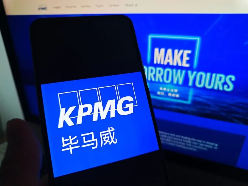SUQIAN, CHINA - MAY 19, 2026 - A netizen is checking KPMG logo on his mobile phone and KPMG webpage on his computer in Suqian City, Jiangsu Province, China on May 19, 2026. (Photo credit should read CFOTO/Future Publishing via Getty Images)