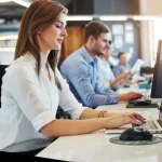 Business woman on laptop in a office taking customer enquiries
