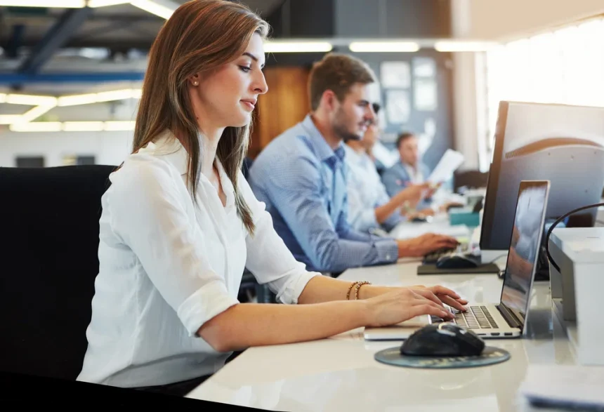 Business woman on laptop in a office taking customer enquiries