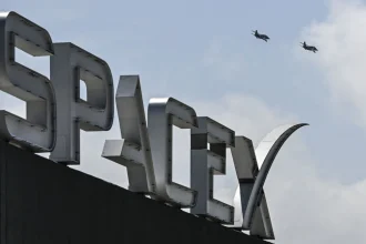 US billionaire businessman and pilot Jared Isaacman flies in formation aboard a fighter jet over the SpaceX sign, close to the Starship spacecraft, before his third test flight from Starbase in Boca Chica, Texas, on March 13, 2024.