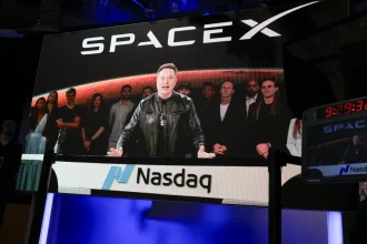 SpaceX CEO Elon Musk, displayed on a screen remotely from SpaceX headquarters in Starbase, Texas, speaks before the launch of SpaceX’s initial public offering (IPO) at the Nasdaq MarketSite in New York on June 12, 2026.