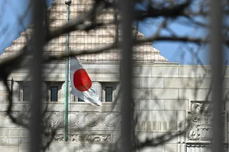 a Japanese flag fluttering in the wind in the distance in front of a building in Tokyo